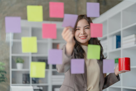 Beautiful young teen asian businesswoman using note pad thinking with planning working on financial document, tax, exchange, accounting and Financial advisor.の写真素材