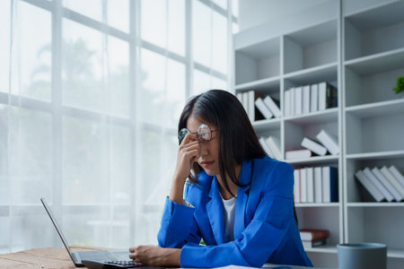 Portrait of business owner, woman using computer and financial statements Anxious expression on expanding the market to increase the ability to invest in business.の写真素材