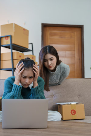 Starting small business entrepreneur of independent Asian woman showing her face worried about the sales of her business not reaching the target set. SME concepts.の写真素材