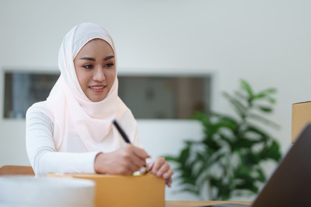 Beautiful Muslim woman selling online at home, business owner, business sme concepts.の写真素材