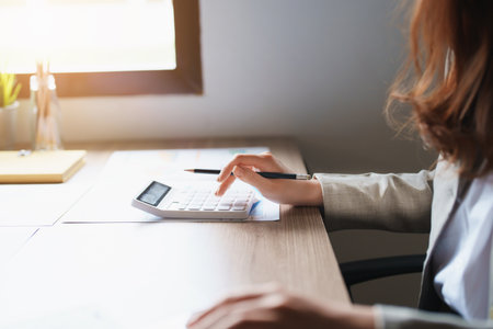 Accountants, Asian auditors are using calculators and computers to review annual tax budgets to submit information to the IRSの写真素材