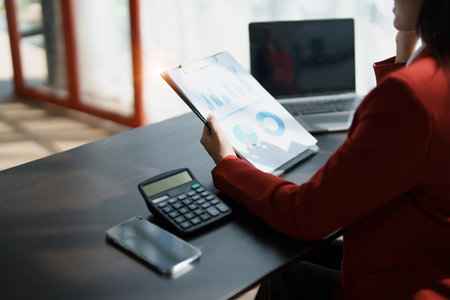 Young asian female work with financial papers at home count on calculator before paying taxes receipts online, planning budget glad to find chance for economy saving money, audit concepts.の写真素材