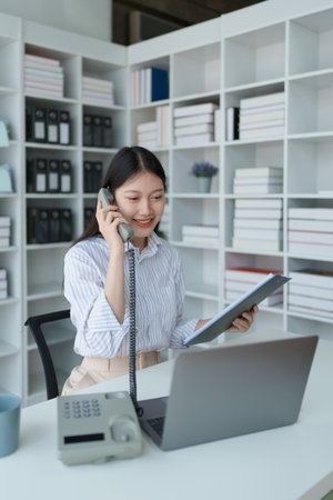 Consultant, Asian businesswoman working on the phone who discussion financial work and marketing business plan to increase company profits, ready to use computer and marketing planning documents.の写真素材