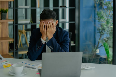 Portrait of business owner, man using computer and financial statements Anxious expression on...