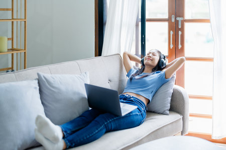 Home lifestyle woman relaxing sleeping on sofa patio living room. Happy lady lying down on comfortable pillows taking a nap for wellness and health. Tropical vacationの写真素材