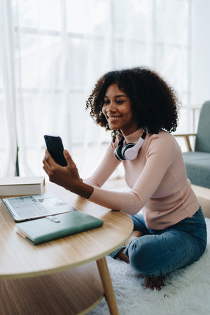 african american university using smartphone mobile foreign exchange students study online on laptop...
