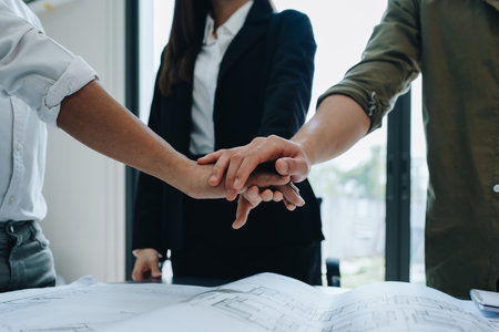 Engineers, designers and interior designers are together hands deal finalizing the design of interiors by discussing selecting materials and colors to design rooms to present to clients.の写真素材