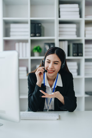 young business woman wear wireless headset video conference calling on laptop computer talk by...