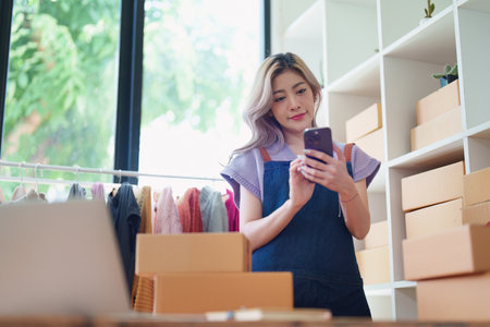 Starting small business entrepreneur of independent Asian female online seller talking on the phone...