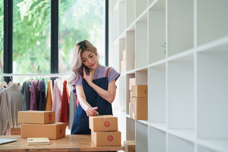 Starting small business entrepreneur of independent Asian female online seller talking on the phone...