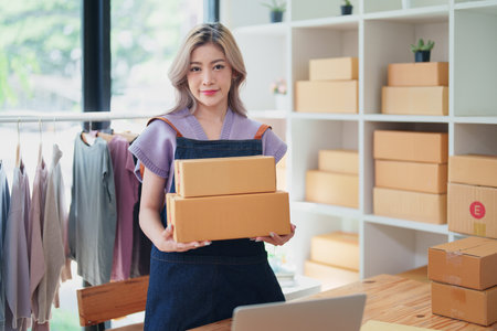Online delivery, female small business owners are ecstatic when they see unexpected sales and customer orders in their business planning and marketing.の写真素材