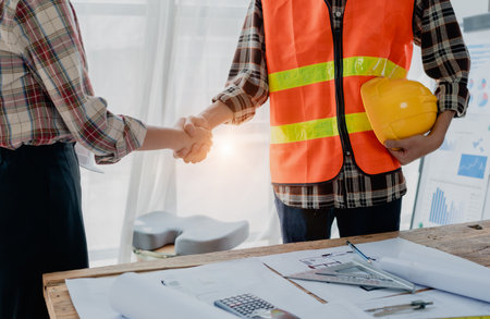 Engineers, designers and interior designers are handshake shack hands deal finalizing the design of...