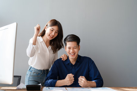 Family couple getting excited about success when they get email with excellent job offer looking at laptop computer with very excited face expressions.の写真素材