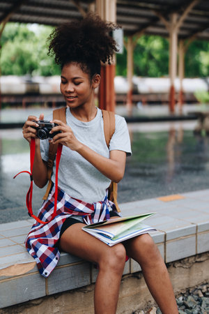 Asian teenage girl african american traveling using a camera take a photo to capture memories while waiting for a train at the stationの写真素材