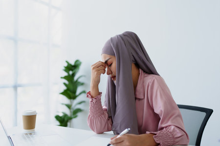Muslim female employee working in office burnoutの写真素材