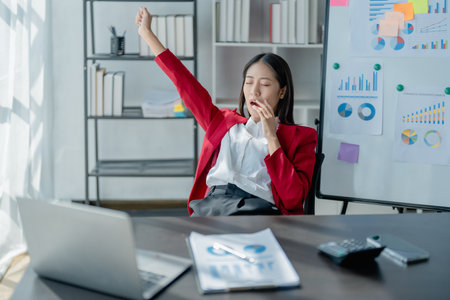 Rear view young businesswoman leaning back in comfortable chair, sitting in modern office, successful woman employee, planning future, visualizing, pondering project strategyの写真素材