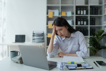 Portrait of business owner, woman using computer and financial statements Anxious expression on...