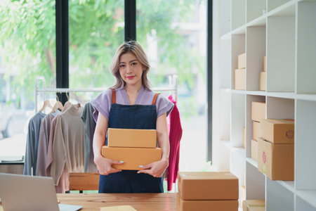 Online delivery, female small business owners are ecstatic when they see unexpected sales and customer orders in their business planning and marketing.の写真素材