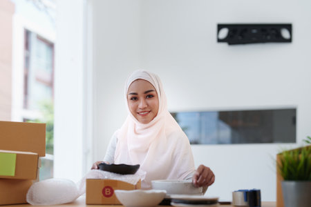 Beautiful Muslim woman selling online at home, business owner, business sme concepts.の写真素材