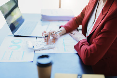 Accountants, Asian auditors are using calculators and computers to review annual tax budgets to...