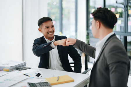 Give me five. managers employees join hands high celebrate common achievement. Two young men successful teammates friends greet each other with great job result.の写真素材