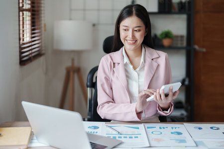 businesswoman or accountant working on calculator and laptop computer to calculate business data during using accountancy document at office.の写真素材