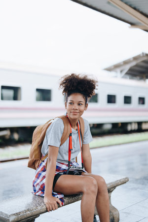 Tourists african american are showing happy expressions while waiting for their journey in the train stationの写真素材