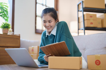 Starting small business entrepreneur of independent Asian female online seller packing products to send to customers and SME delivery concept.の写真素材