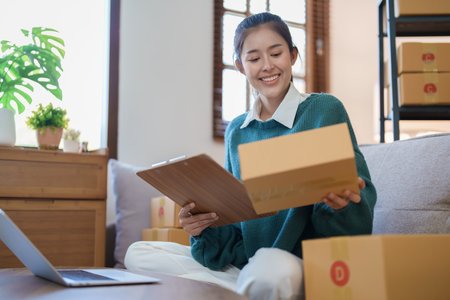 Starting small business entrepreneur of independent Asian female online seller packing products to send to customers and SME delivery concept.の写真素材