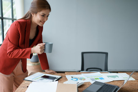 Businesswoman enjoys relaxing with a cup of coffee after a long dayの写真素材