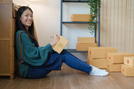 Starting small business entrepreneur of independent young Asian woman online seller is using...