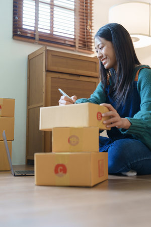 Starting small business entrepreneur of independent Asian female online seller packing products to send to customers and SME delivery concept.の写真素材