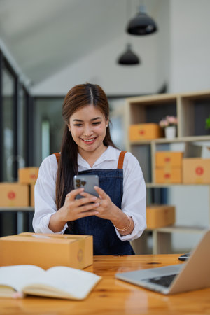 Excited young woman celebrating success while using smartphone to see data delivery products customer profit.の写真素材