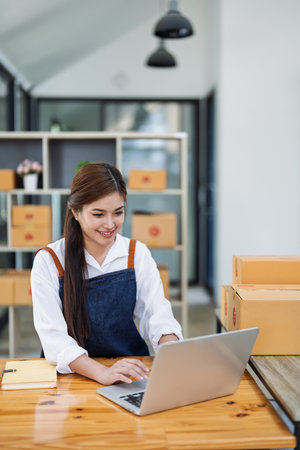 Excited young woman celebrating success while using computer laptop to see data delivery products customer profit this month.の写真素材