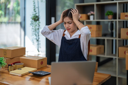Young woman engaged in online business with stress thoughtful within data products sales did not meet target selling products of this month.の写真素材