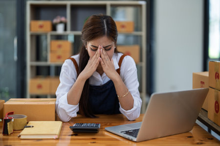 Young woman engaged in online business with stress thoughtful within data products Sales did not meet target Selling products of This month.の写真素材
