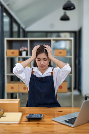 Young woman engaged in online business with stress thoughtful within data products Sales did not meet target Selling products of This month.の写真素材