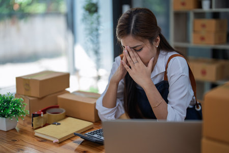 Young woman engaged in online business with stress thoughtful within data products Sales did not meet target Selling products of This month.の写真素材