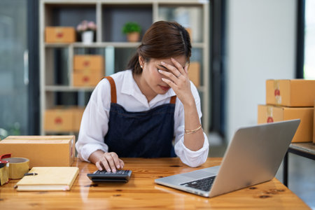 Young woman engaged in online business with stress thoughtful within data products Sales did not meet target Selling products of This month.の写真素材
