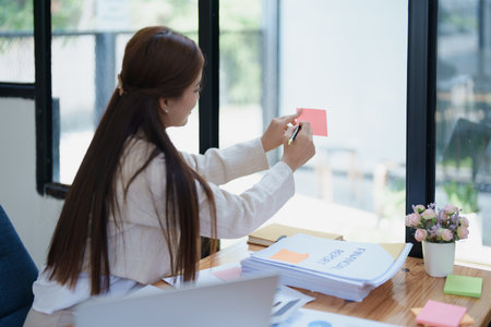 professional businesswoman with planning takes a notepad financial documents and marketing charts at work.の写真素材