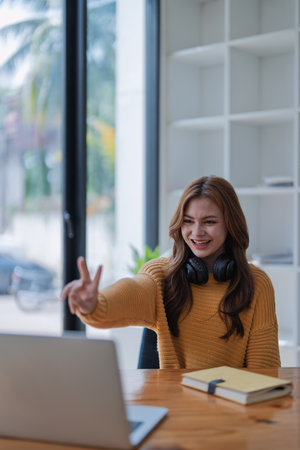young woman happy, viewing her excellent success score in her e-learning program displayed on her laptop at her desk at home.の写真素材