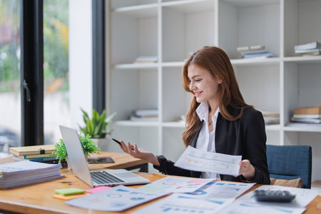 Young business woman analyzes financial reports at her office workplace..の写真素材