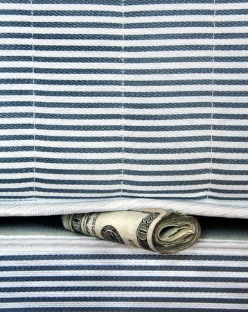 A roll of money tucked in a mattress for safekeeping.