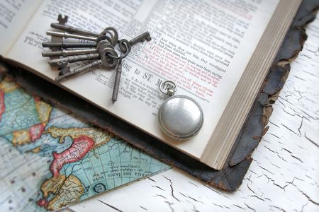 Antique Bible with keys, watch, and a map.の写真素材