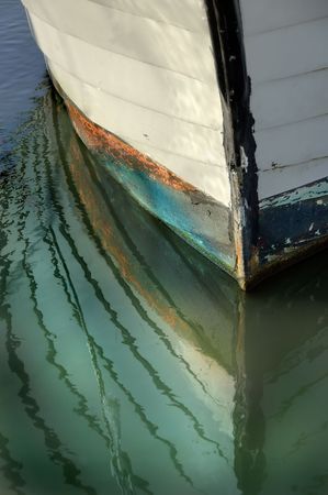 Boat bow reflections in the still water.