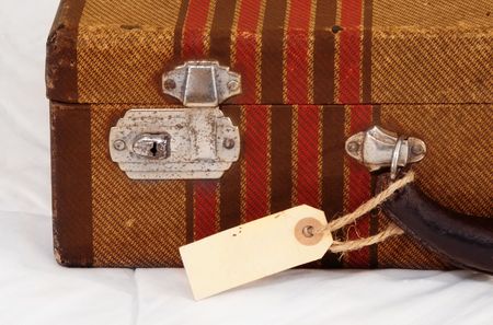 Vintage suitcase with a blank luggage tag or label.の写真素材