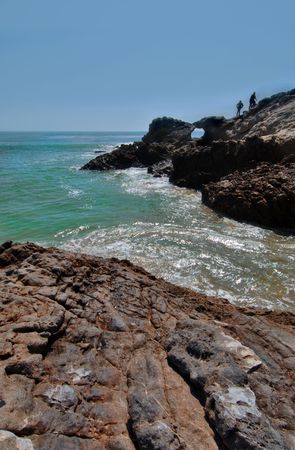 Rocky shore with hikers in Malibu California.