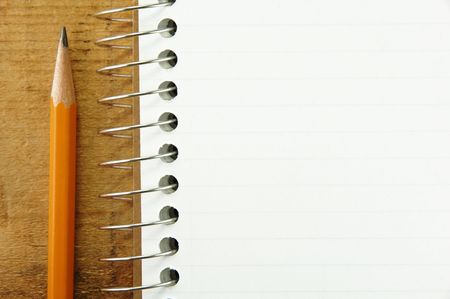 Pencil by small pad of lined paper blank for your text.の写真素材