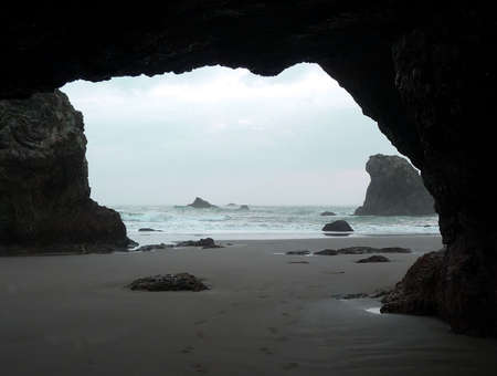A footprint trail leads in and out of a beach along a sandy coastの写真素材