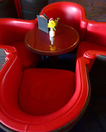 Contemporary red leather chairs around small round tableの写真素材